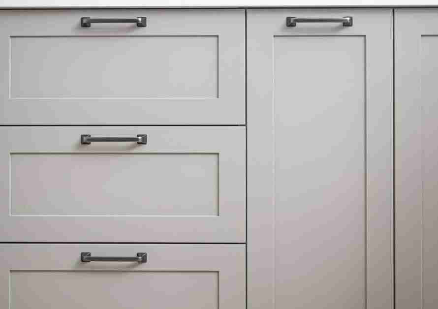 Light gray cabinets and drawers of different widths and heights. They have sleek, metal, modern-looking hardware.