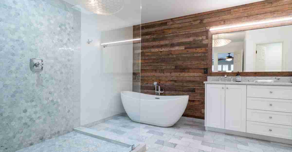 A stylish and spacious bathroom with a glass walk-in shower, a standing tub, tile flooring, and a wooden accent wall.